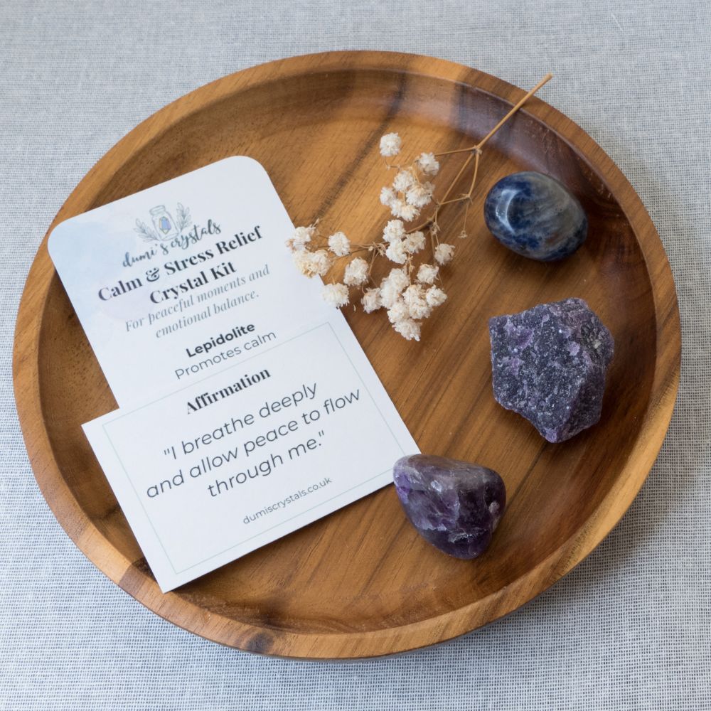 Crystal kit with stones and card on a wooden tray