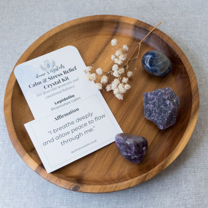Crystal kit with stones and card on a wooden tray