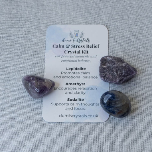 Crystal kit with Lepidolite, Amethyst, and Sodalite on a card labeled 'Calm & Stress Relief Crystal Kit' by dumiscrystals.co.