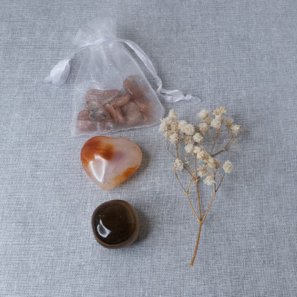 Collection of stones and a small plant on a textured surface