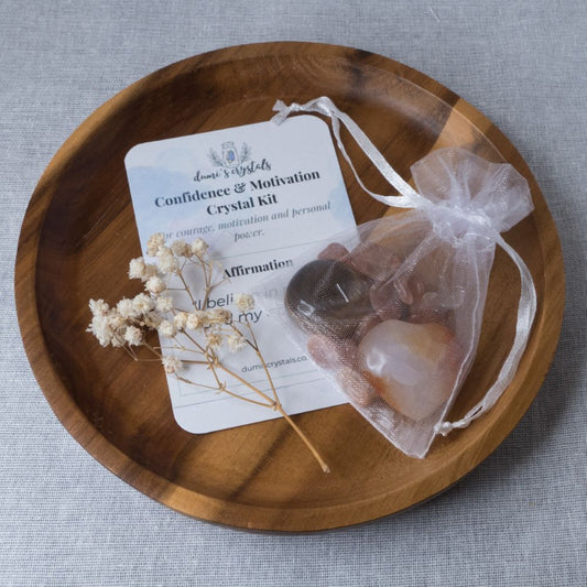Crystal kit with stones and a card on a wooden tray