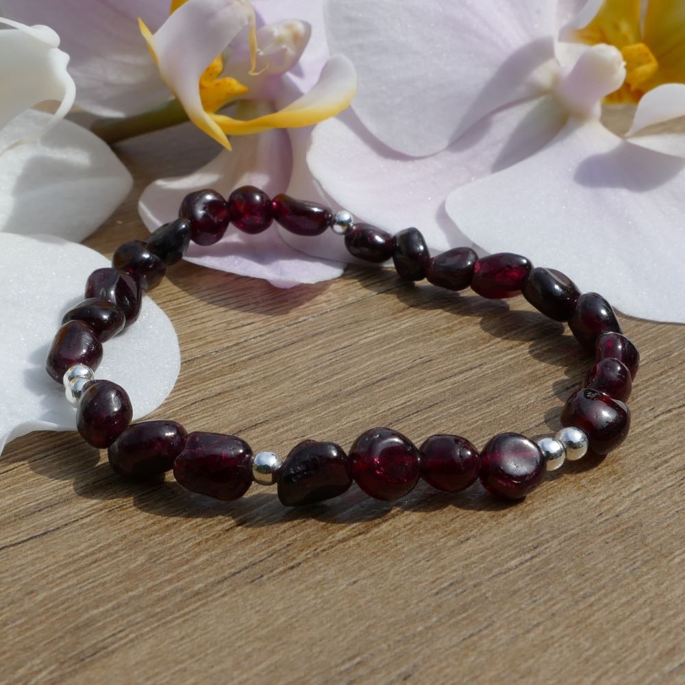 image of a bracelet made with garnet nuggets and silver plated beads. this bracelet is available at dumi's crystals