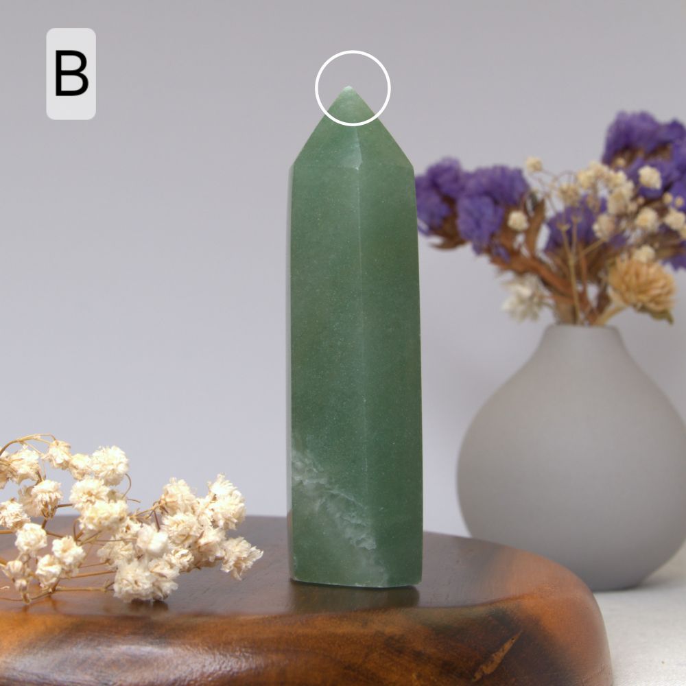 green aventurine tower on a wooden plate with dried flowers in the background