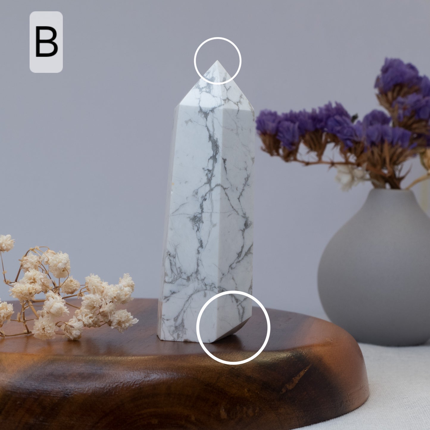 howlite tower on a wooden stand with flowers and a vase in the background