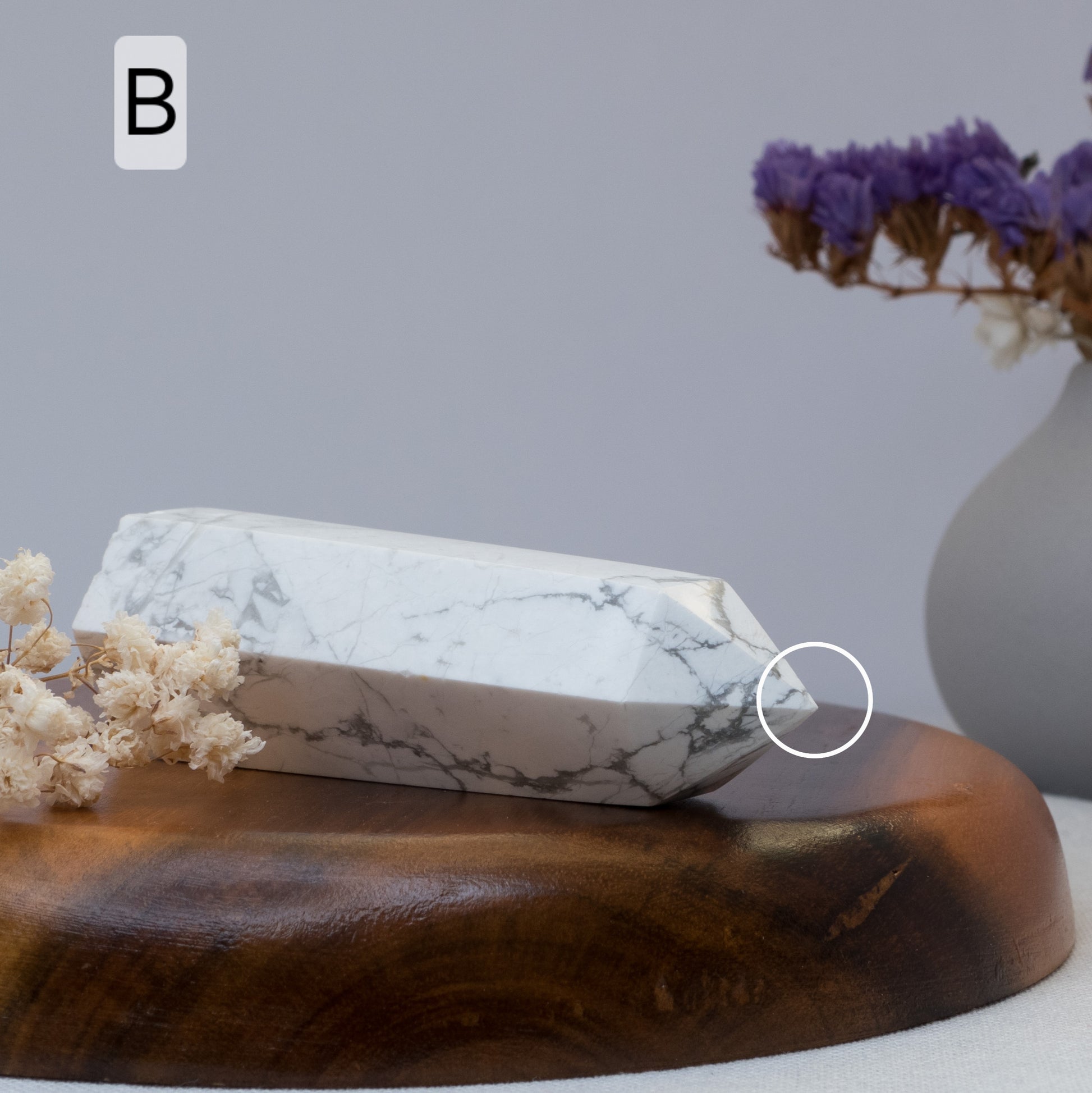 howlite tower on a wooden surface with flowers and a vase in the background