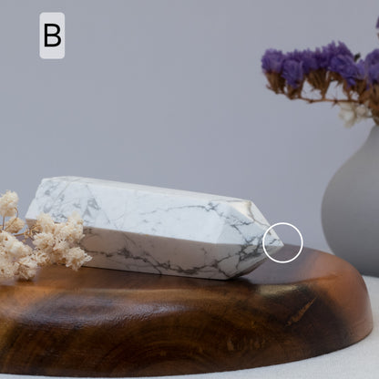 howlite tower on a wooden surface with flowers and a vase in the background