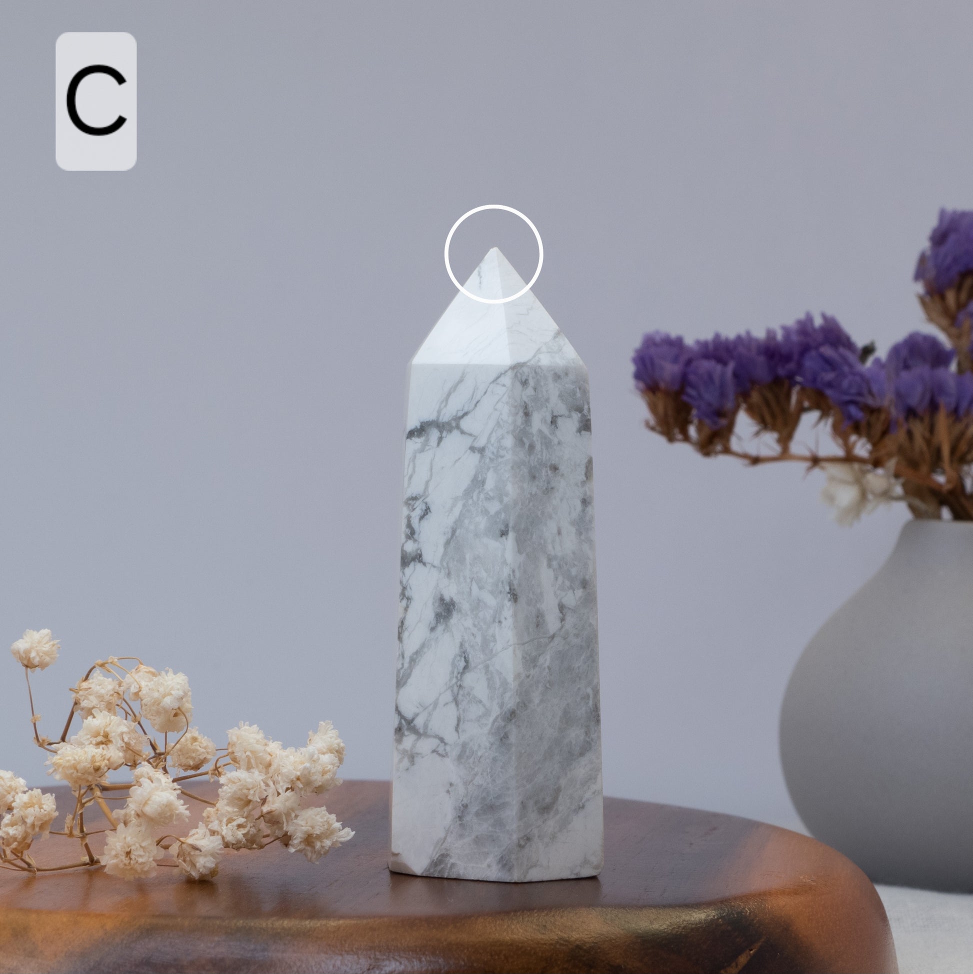 howlite tower on a wooden surface with flowers and a vase in the background