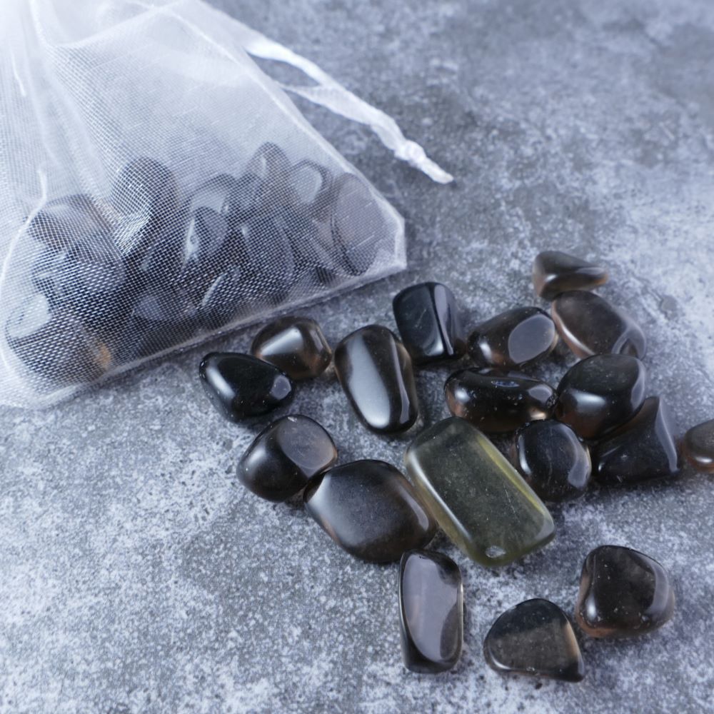 Dumi's Crystals | Ice Obsidian Chips (1-2cm) | Close-up of a collection of genuine Ice Obsidian chips, highlighting their distinctive icy sheen and variations in size and texture. Ice Obsidian is revered for its ability to shield against negativity, promote inner strength, and foster spiritual growth.