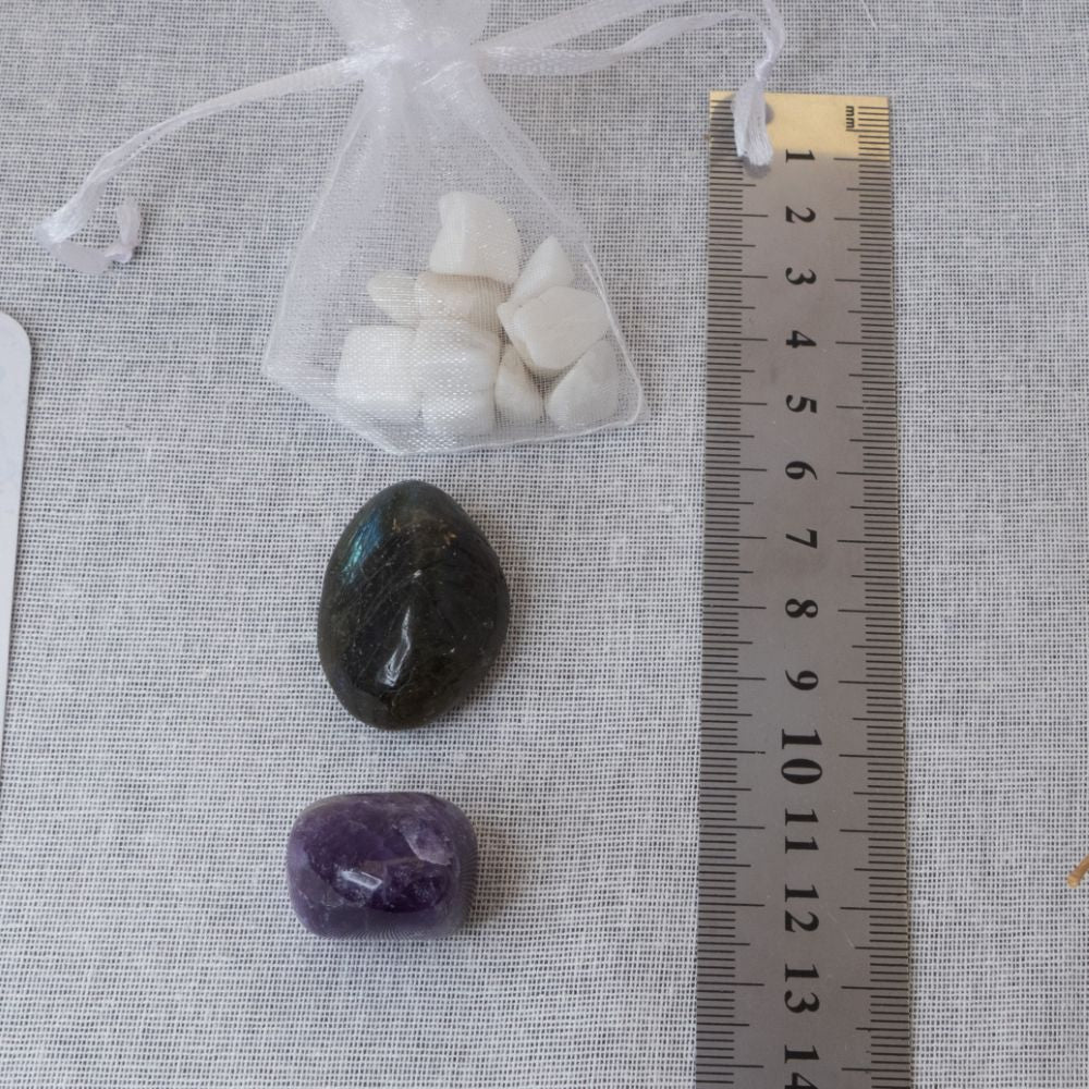 amethyst tumblestone, labradorite tumblestone and white moonstone chips in an organza bag with a ruler for size comparison