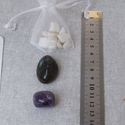 amethyst tumblestone, labradorite tumblestone and white moonstone chips in an organza bag with a ruler for size comparison