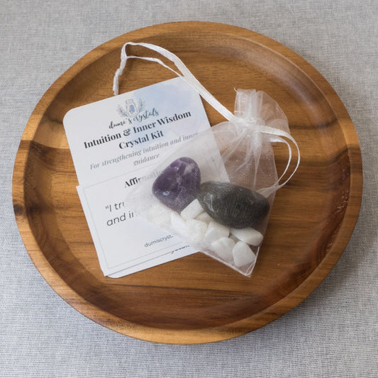 intuition crystal kit with white moonstone chips, amethyst tumble stone and labradorite tumblestone in an organza pouch, cards on a wooden plate