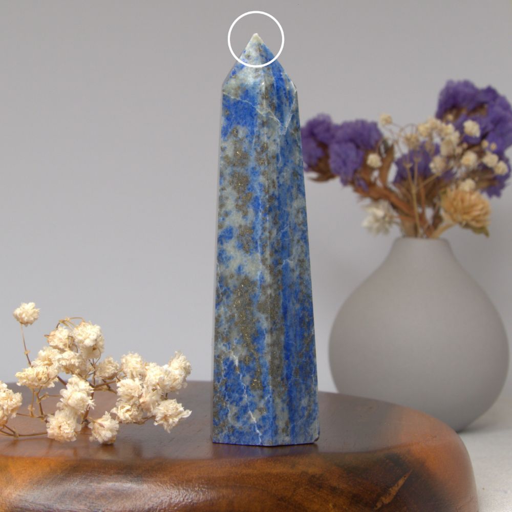 lapis lazuli tower on a wooden surface with flowers in the background