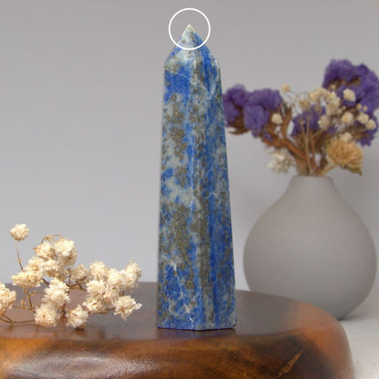lapis lazuli tower on a wooden surface with flowers in the background