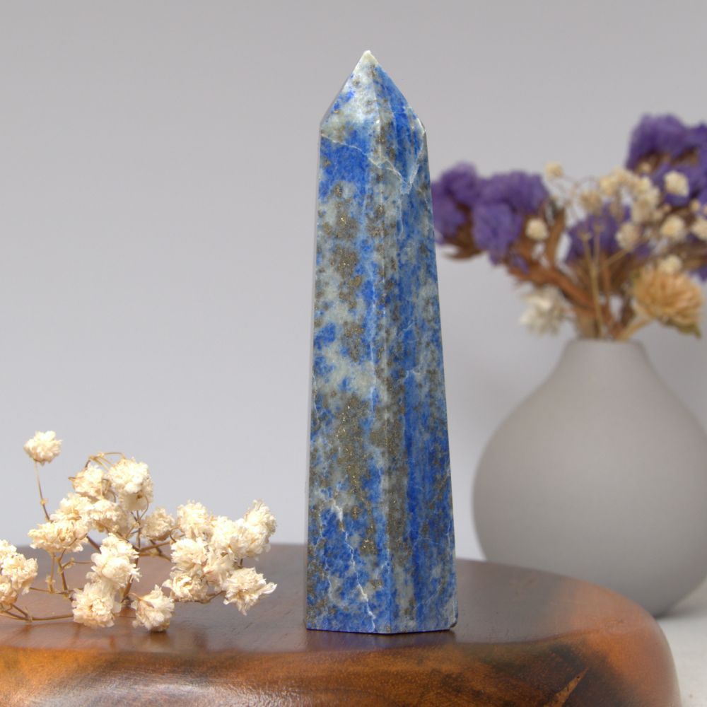 lapis lazuli tower on a wooden surface with flowers in the background