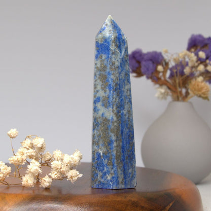 lapis lazuli tower on a wooden surface with flowers in the background