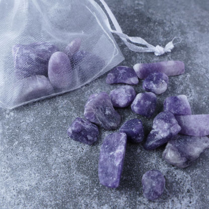 Dumi's Crystals | Lepidolite Chips (1-2.5cm) | Close-up of a collection of genuine Lepidolite chips, highlighting their captivating lilac color and variations in texture. Lepidolite is revered for its ability to promote emotional balance, peace, and emotional support.