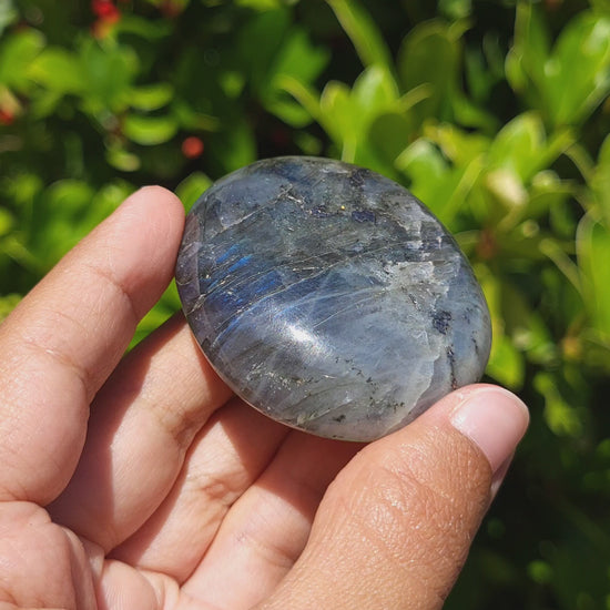 video showing the shimmer of a labradorite palm stone