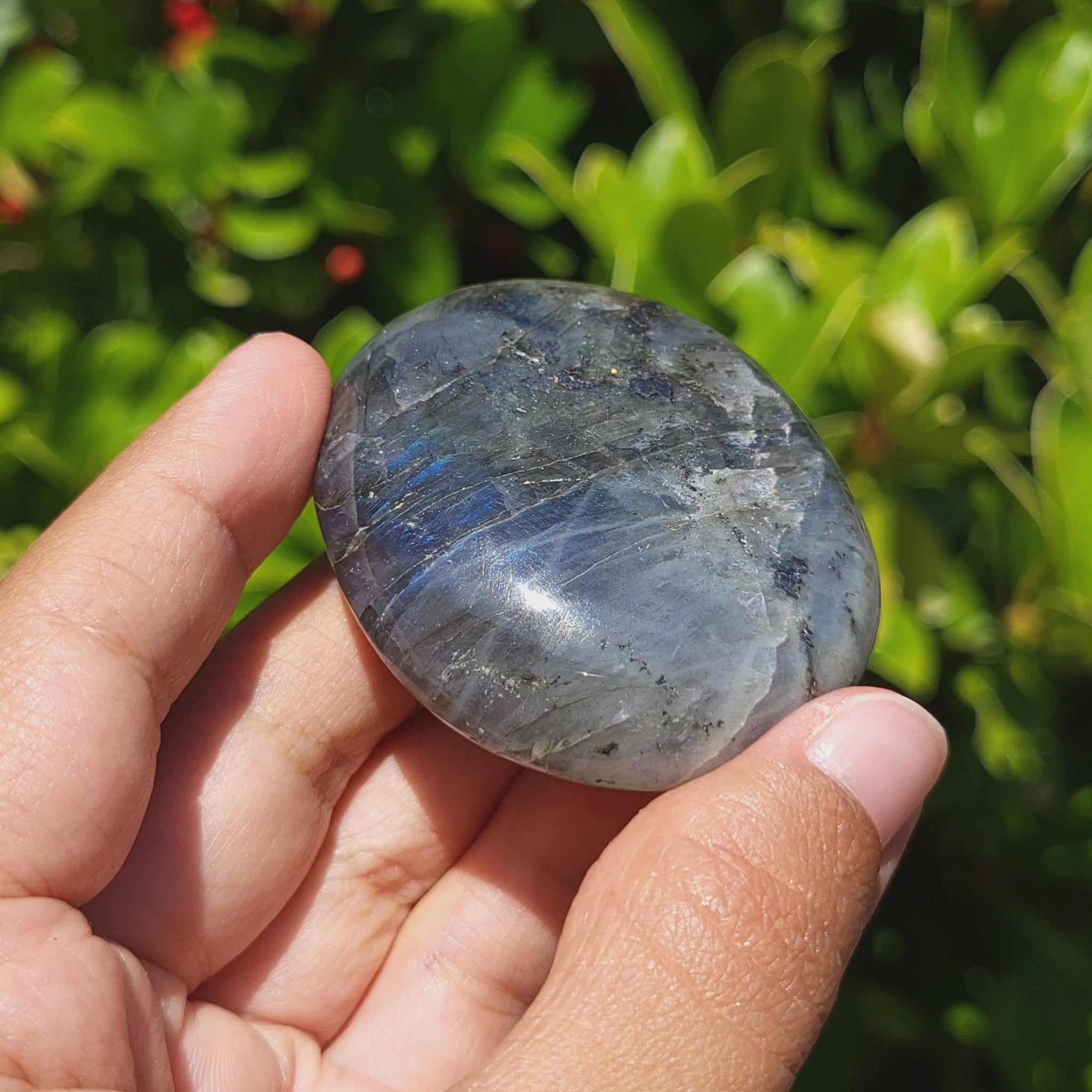 video showing the shimmer of a labradorite palm stone
