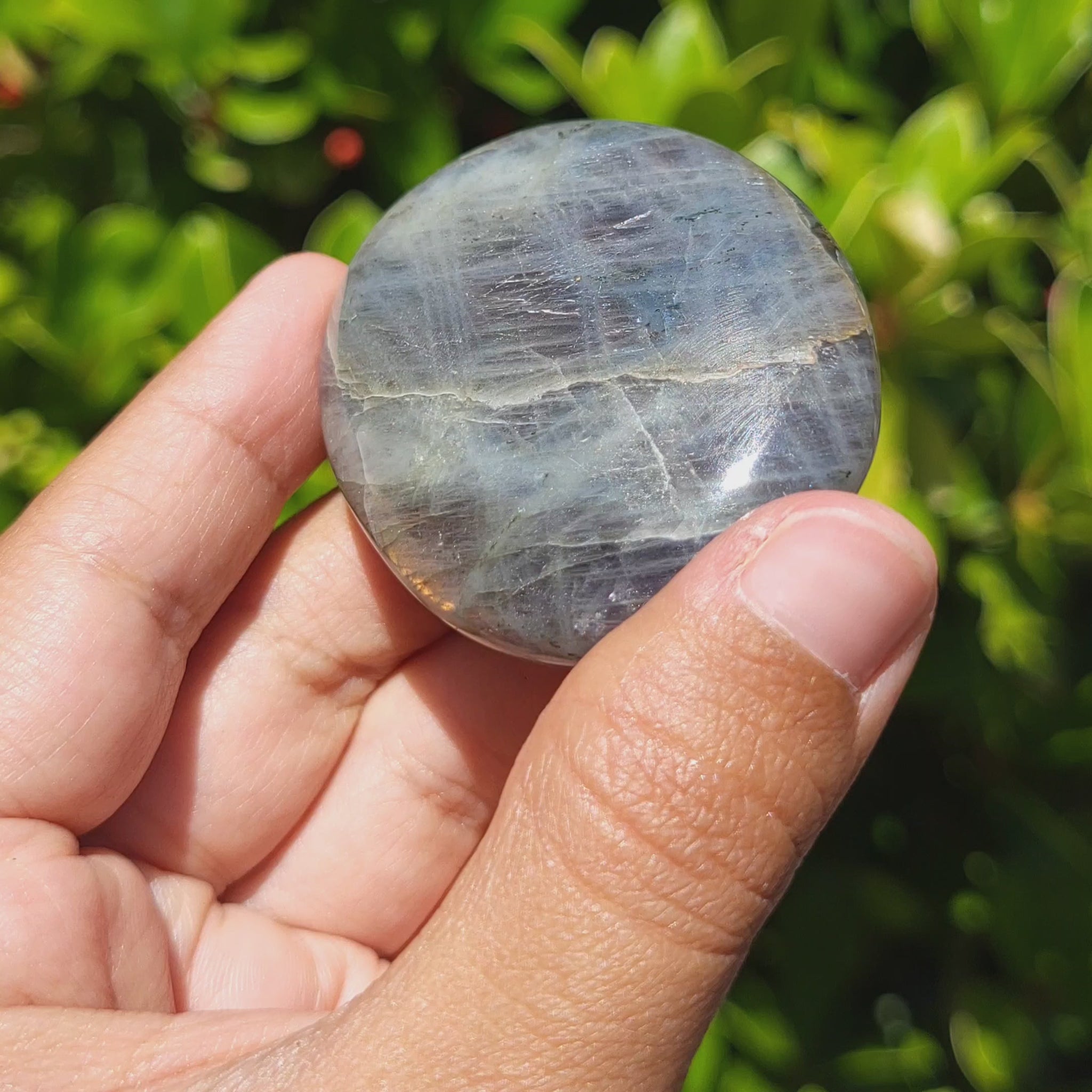 video showing the labradorescence of a labradorite palm stone 