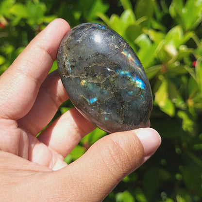 video showing the flash of a labradorite palm stone