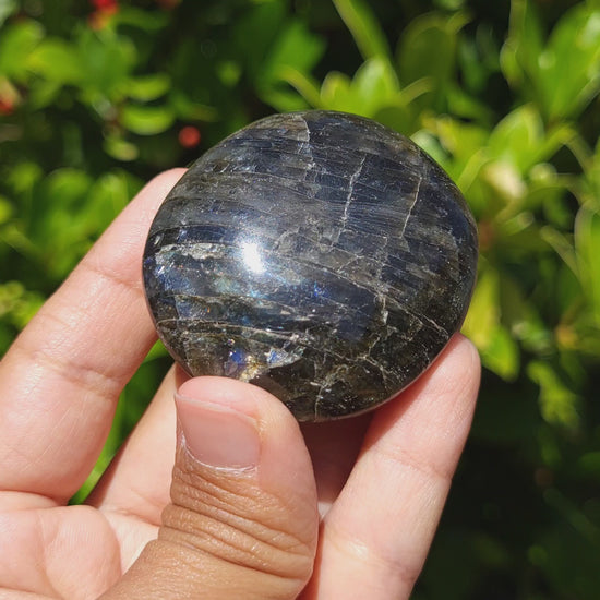 video showing the flash of a labradorite palmstone