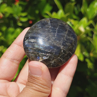video showing the flash of a labradorite palmstone