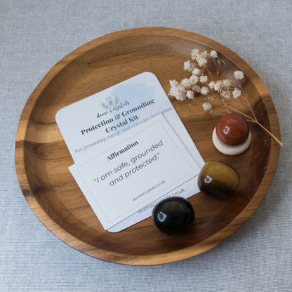 Wooden tray with crystal kit components and a card on a gray surface