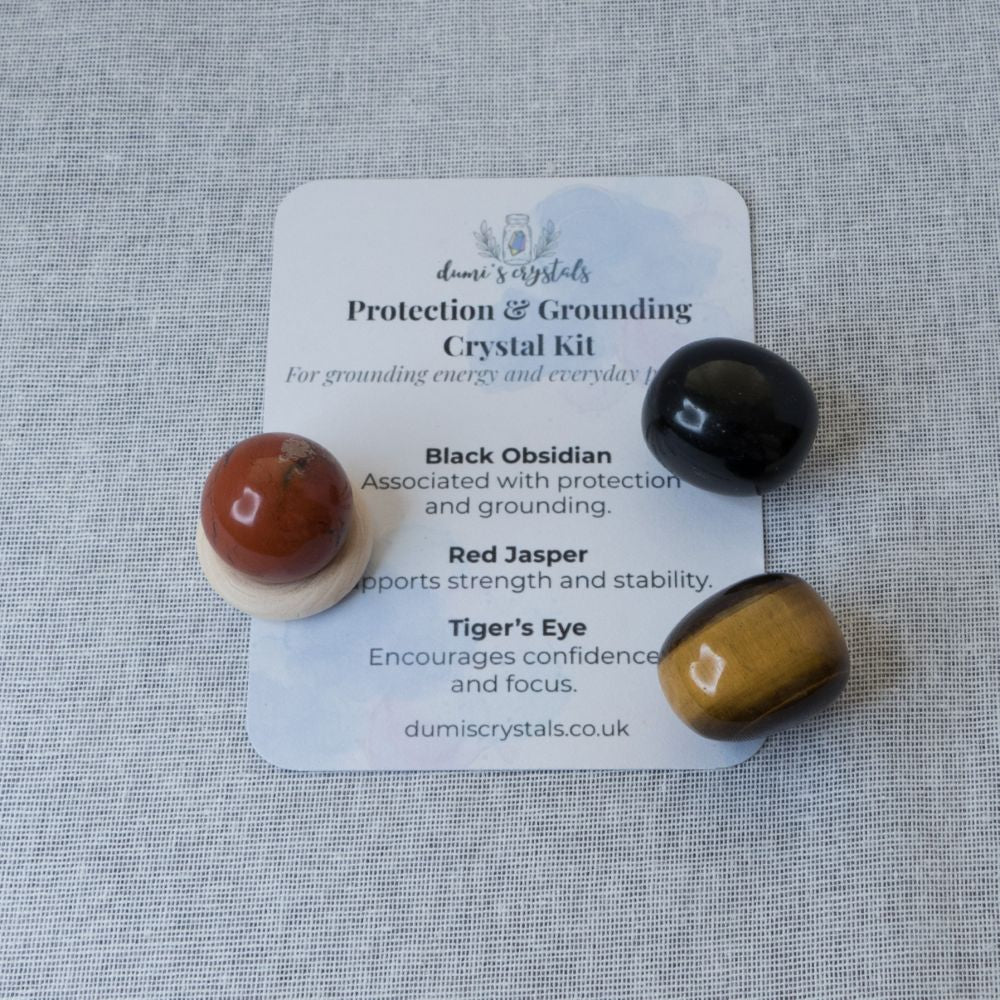 Crystal kit with black obsidian, red jasper, and tiger's eye on a gray background