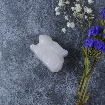 Dumi's Crystals | Rose Quartz Bunny Carving (Heart's Embrace): A Rose Quartz Crystal Bunny Carving, crafted from delicate light pink, almost white stone. This symbol of love & compassion invites you to open your heart and embrace emotional healing. Find love within with Dumi's Crystals (ethically sourced).