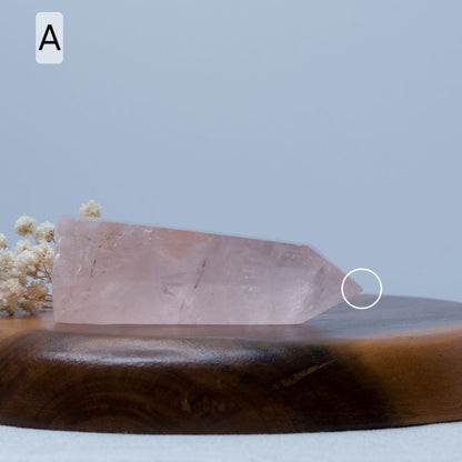 rose quartz tower on a wooden surface with a blurred background