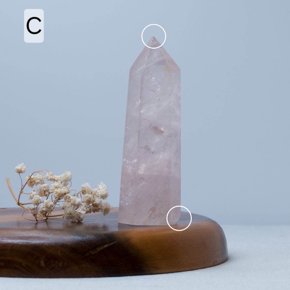 rose quartz Crystal tower on a wooden base with a light blue background