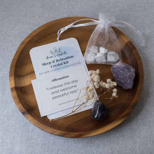 Sleep and relaxation crystal kit with stones, card, and amethyst on a wooden tray.