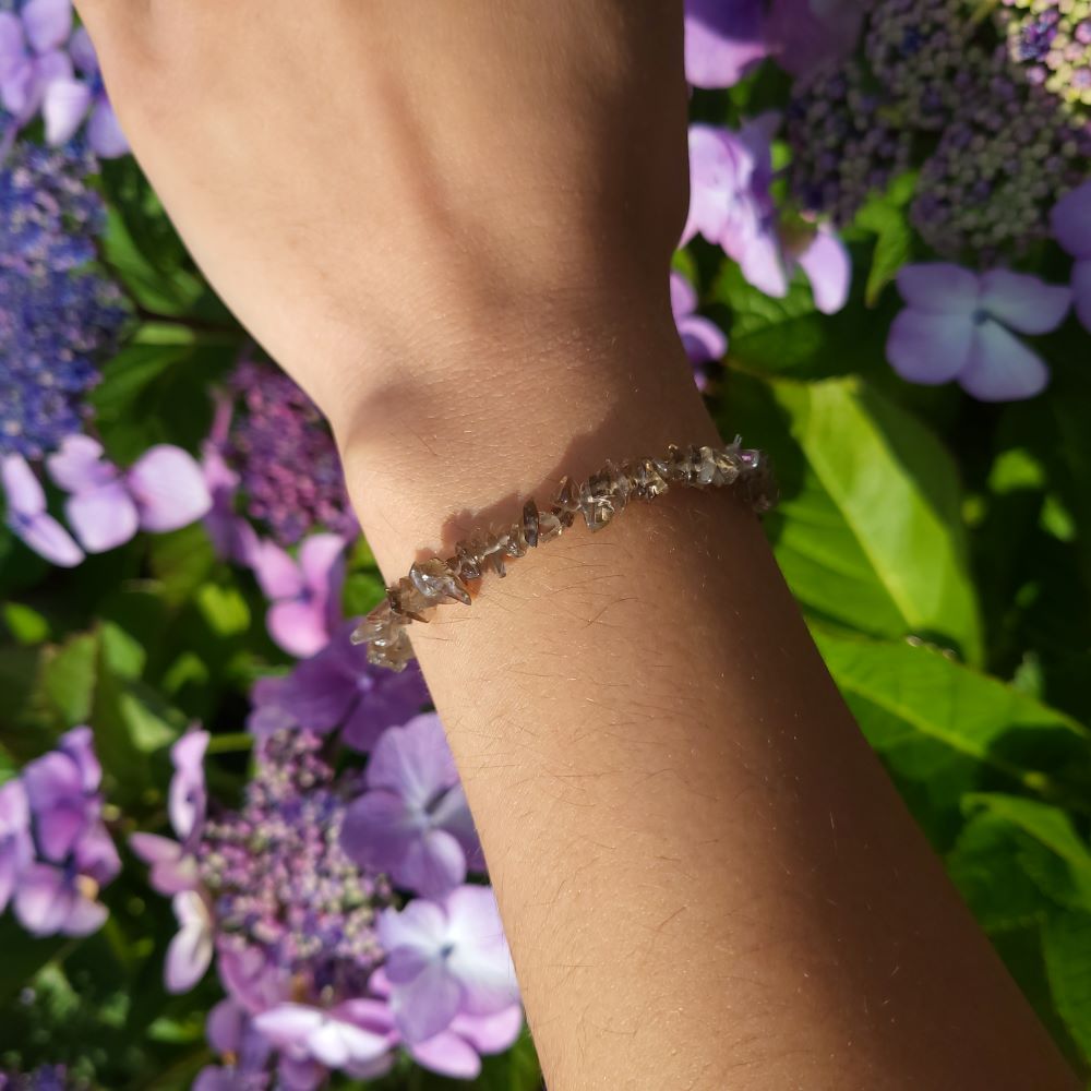Dumi's Crystals | Smoky Quartz Chip Stretch Bracelet (7 Inch) | Showcasing the captivating beauty of Smoky Quartz chips on a wrist. This bracelet promotes grounding, protection, emotional healing, and mental clarity. Smoky Quartz, the grounding stone, is known for its deep, earthy hues.