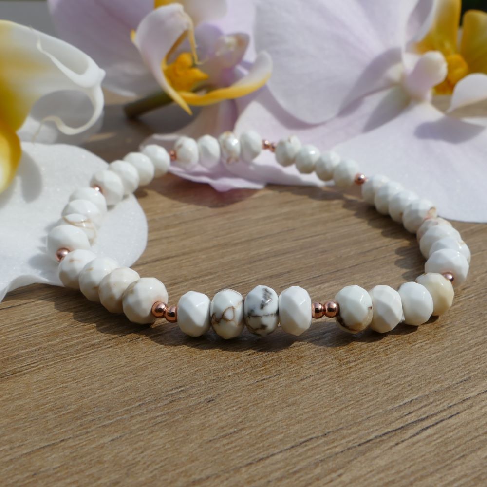 image of a bracelet made with white magnesite rondelles and rose gold beads. this bracelet is available at dumi's crystals