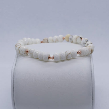 image of a bracelet made with white magnesite rondelles and rose gold beads. this bracelet is available at dumi's crystals