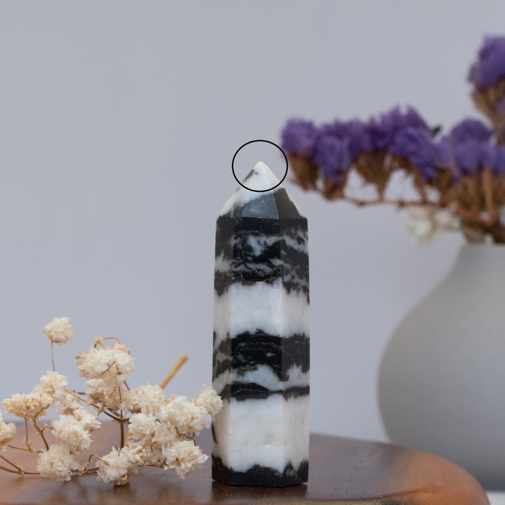Black and white striped crystal tower with flowers in the background