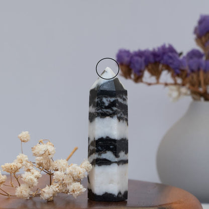 Black and white striped crystal tower with flowers in the background