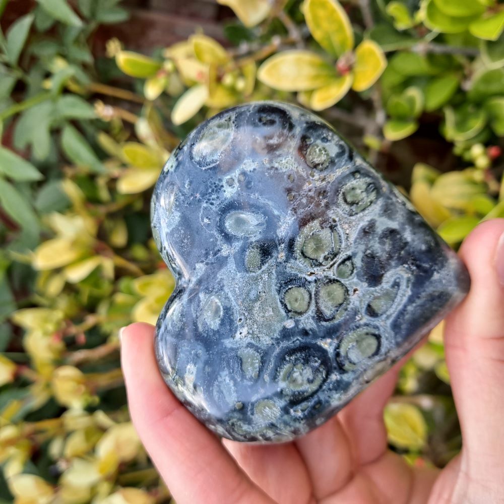 Dumi's Crystals | Large Kambaba Jasper Heart Carving (Centerpiece for Growth): A stunning large Kambaba Jasper Heart Carving, a symbol of renewal and growth. Measuring 3 inches tall, its rich green hues & orbicular patterns connect you to the earth's energy. Invite positive energy & embrace life's cycles with Dumi's Crystals (ethically sourced).