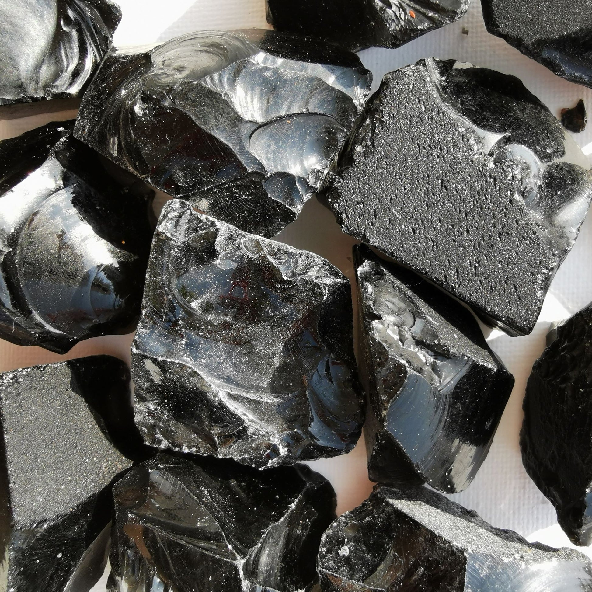 Dumi's Crystals | Rough Black Obsidian Crystals (Grounding & Transformation) | A collection of Rough Black Obsidian Crystals, reminders of your inner resilience. Black Obsidian promotes emotional balance, reduces negativity & aids self-discovery. Scatter them in your home or workspace to create a protected space overflowing with grounding energy and a sense of empowered transformation.