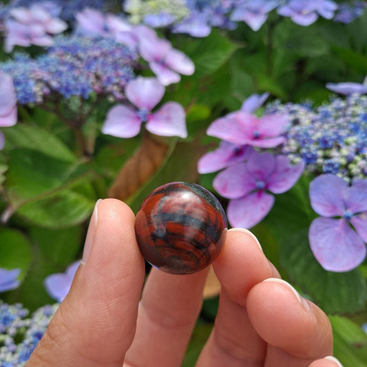 Dumi's Crystals | Bloodstone Mini Sphere (20mm) | A close-up view of a captivating Bloodstone Mini Sphere, showcasing its vibrant green hues speckled with red. This 20mm sphere ignites your inner fire, promoting strength, courage, and a renewed sense of vitality. It's also believed to foster emotional healing, balance, and a positive outlook on life.