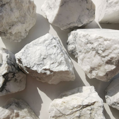 Dumi's Crystals | Rough Howlite Crystals (Calmness & Sleep) | A collection of Rough Howlite Crystals, reminders of your inner peace. Howlite fosters calmness, reduces negativity & promotes restful sleep. Scatter them in your bedroom or meditation space to create a tranquil environment, quieten your mind & enjoy deep sleep. Embrace the power of Rough Howlite from Dumi's Crystals!
