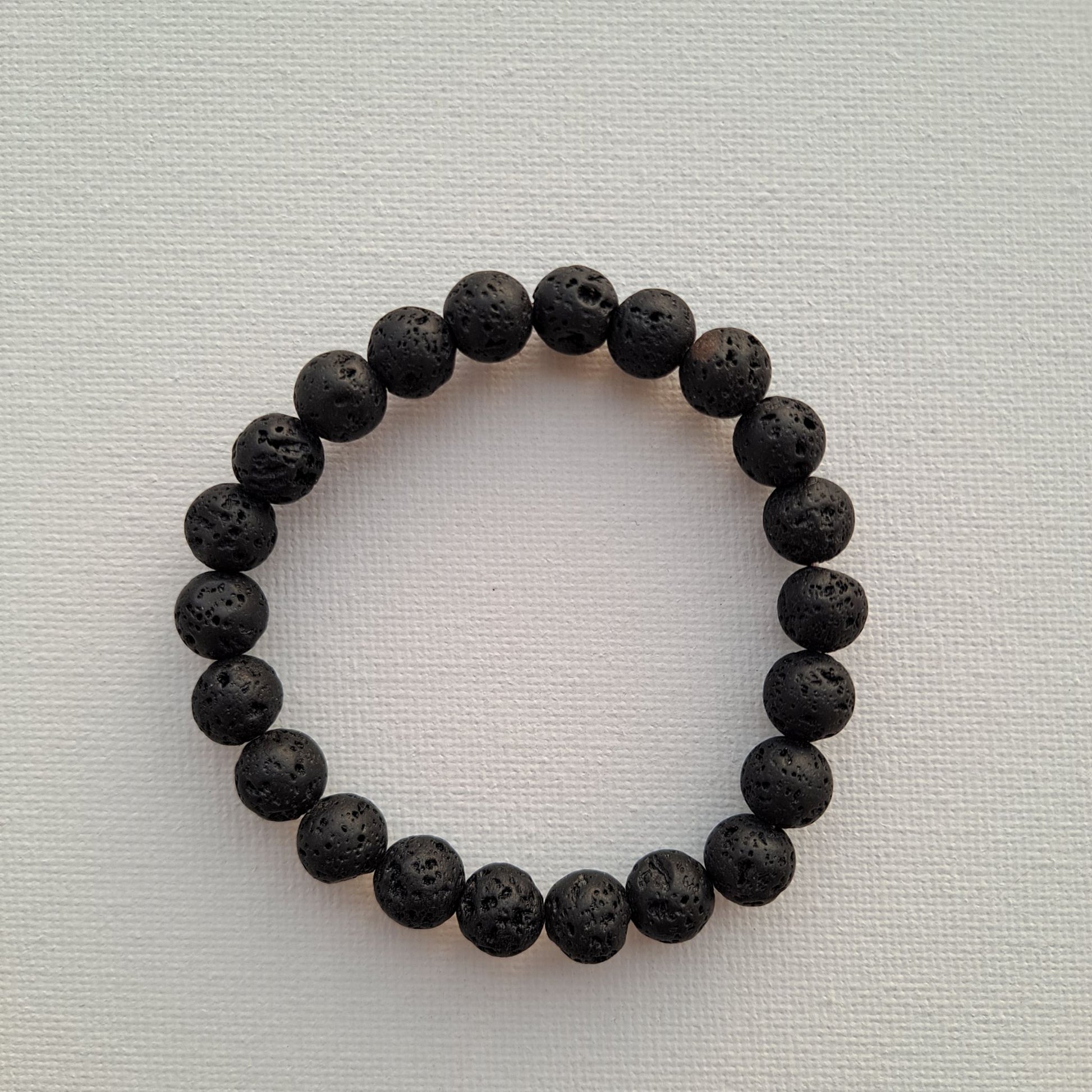 Dumi's Crystals | Lava Stone Stretch Bracelet (8mm) | Close-up of a handcrafted bracelet featuring genuine 8mm Lava Stone beads. Known for their grounding energy, these porous volcanic rock beads can also be used to diffuse your favourite essential oils.