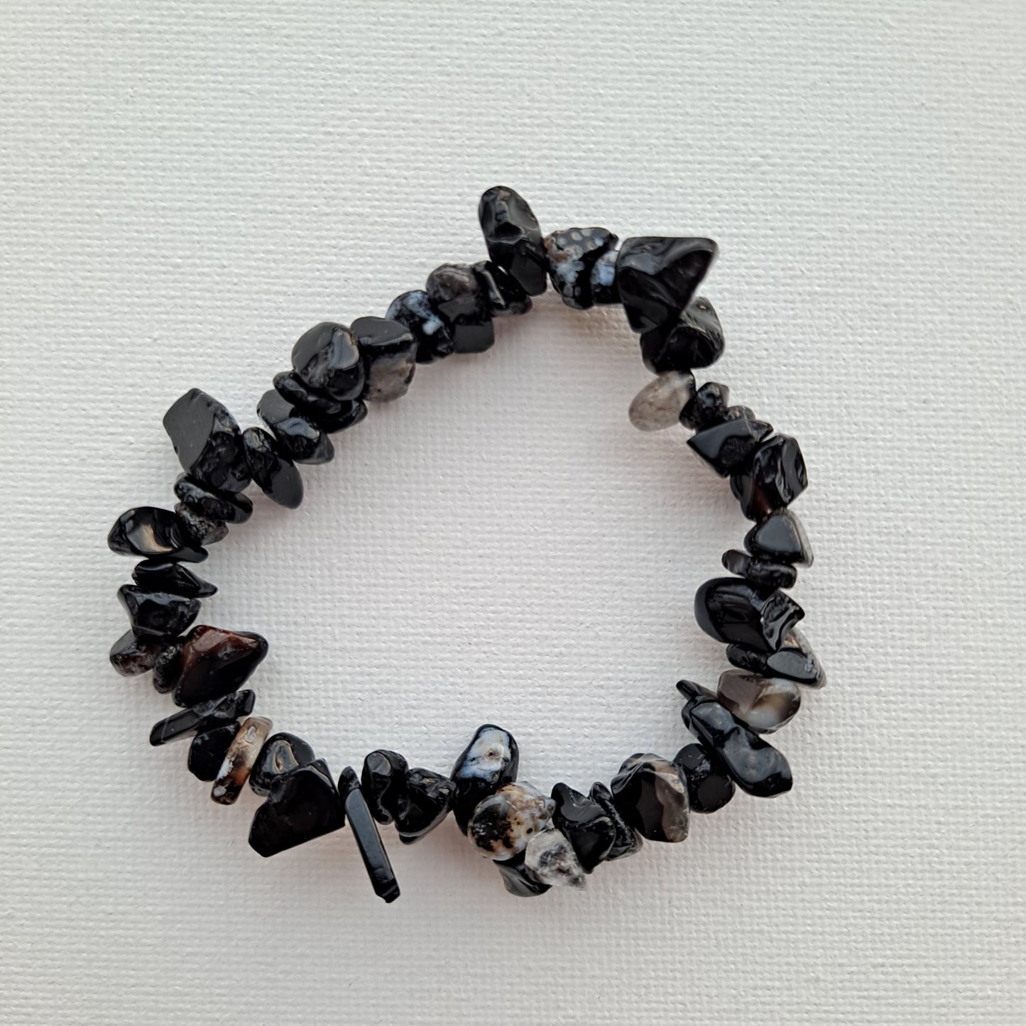 Dumi's Crystals | Black Onyx Stretch Bracelet | Close-up view of a handcrafted bracelet featuring genuine Black Onyx chips in a deep black luster. Known for its grounding properties, protection against negativity, and fostering inner strength.
