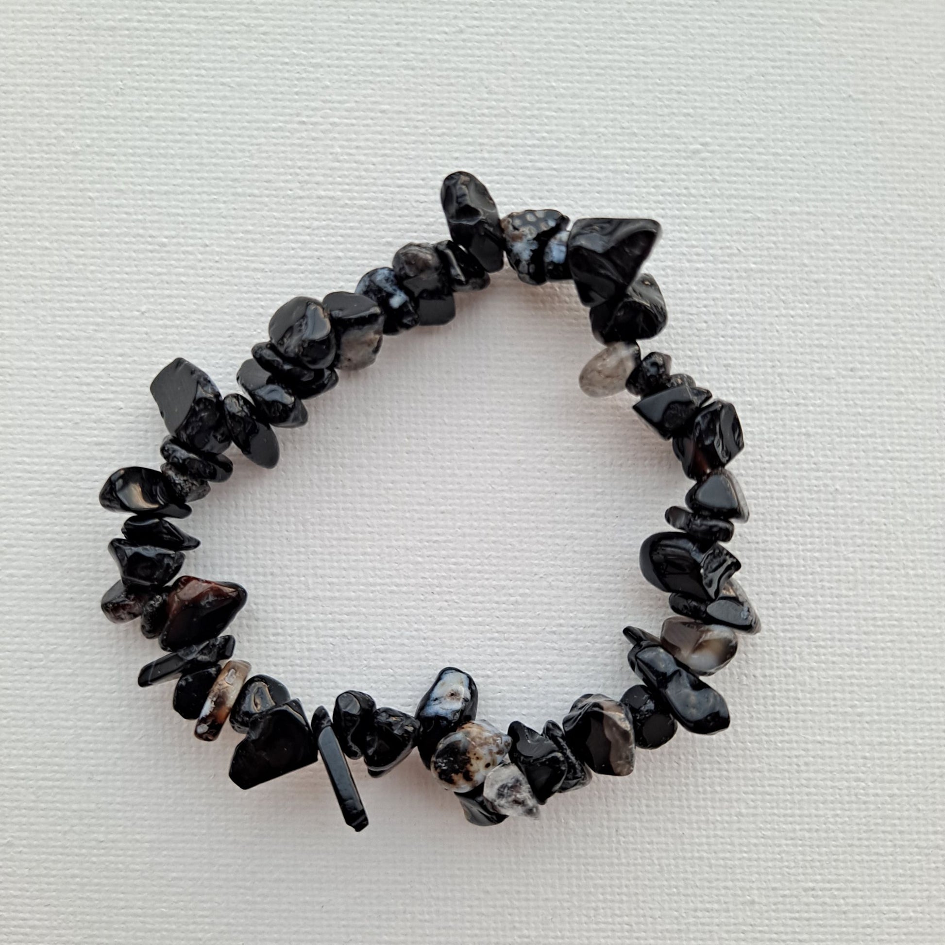 Dumi's Crystals | Black Onyx Stretch Bracelet | Close-up view of a handcrafted bracelet featuring genuine Black Onyx chips in a deep black luster. Known for its grounding properties, protection against negativity, and fostering inner strength.