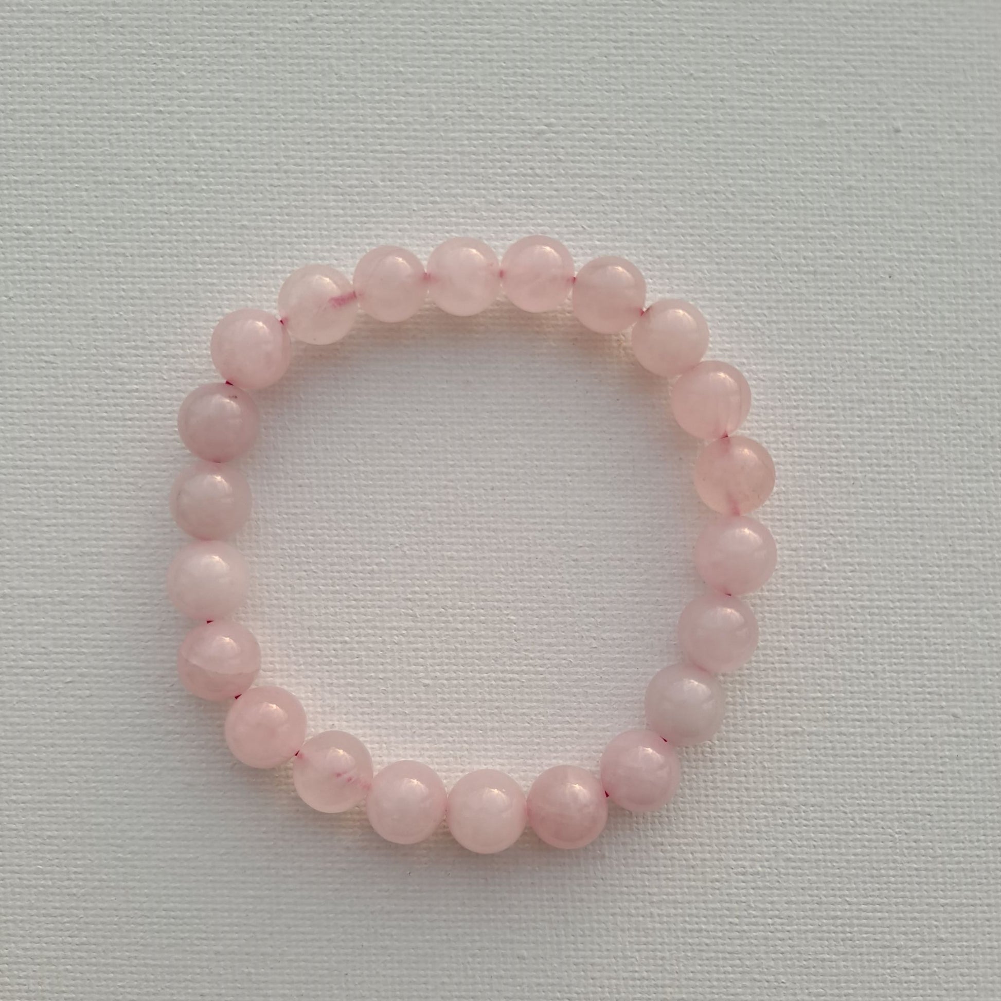 Dumi's Crystals | 8mm Rose Quartz Stretch Bracelet (7 Inch) | Close-up of a handcrafted bracelet featuring genuine 8mm Rose Quartz beads in rich pink hues. Rose Quartz is known as the stone of unconditional love and is believed to promote emotional healing and self-love.