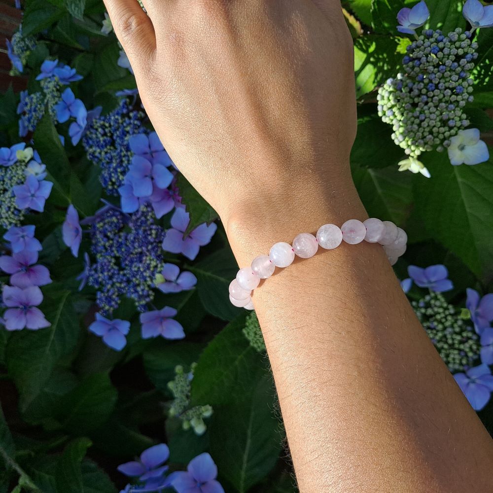  Dumi's Crystals | 8mm Rose Quartz Stretch Bracelet (7 Inch) | Showcasing the captivating beauty of 8mm Rose Quartz beads on a wrist. This bracelet promotes emotional healing, self-love, and fosters confidence. Rose Quartz, the stone of unconditional love, is known for its rich pink hues.
