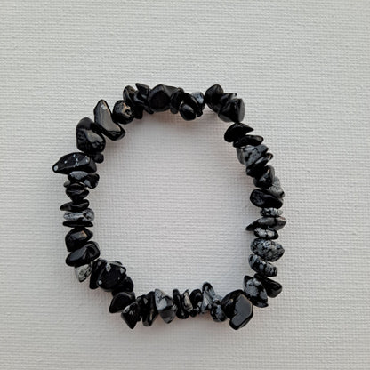 Dumi's Crystals | Snowflake Obsidian Chip Stretch Bracelet (7 Inch) | Close-up of a handcrafted bracelet featuring genuine Snowflake Obsidian chips with contrasting black and white snowflake inclusions. Snowflake Obsidian is known as the stone of transformation and is believed to promote self-discovery, emotional healing, and self-love.