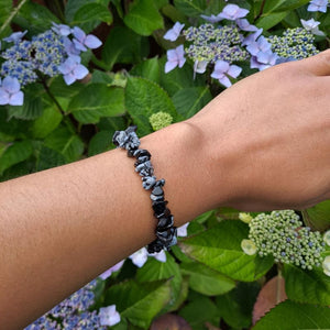  Dumi's Crystals | Snowflake Obsidian Chip Stretch Bracelet (7 Inch) | Showcasing the captivating beauty of Snowflake Obsidian chips on a wrist. This bracelet promotes self-discovery, inner reflection, emotional healing, and self-acceptance. Snowflake Obsidian, the stone of transformation, is known for its black base with contrasting white snowflake patterns.
