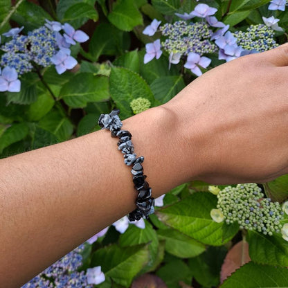  Dumi's Crystals | Snowflake Obsidian Chip Stretch Bracelet (7 Inch) | Showcasing the captivating beauty of Snowflake Obsidian chips on a wrist. This bracelet promotes self-discovery, inner reflection, emotional healing, and self-acceptance. Snowflake Obsidian, the stone of transformation, is known for its black base with contrasting white snowflake patterns.