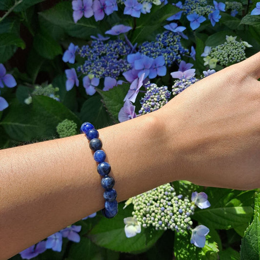 Dumi's Crystals | Sodalite Stretch Bracelet (8mm Beads) (7 Inch) | Showcasing the captivating beauty of 8mm beads on a wrist. This bracelet promotes clear communication, self-expression, inner wisdom, and mental clarity. Sodalite, the stone of truth and communication, is known for its deep blue hues.